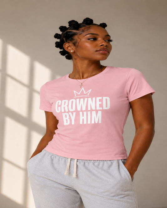 Person wearing a pink t-shirt with 'Crowned by Him' text and gray sweatpants.